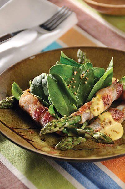 Ensalada de espinacas con espárragos envueltos en tocino