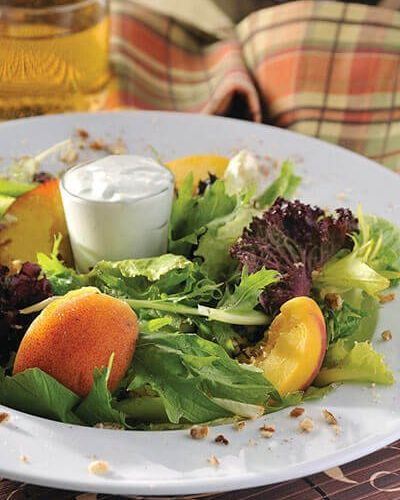 Ensalada de duraznos con aderezo de yogurt y queso azul