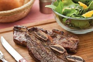 Costilla de res y ensalada de espinaca y naranja
